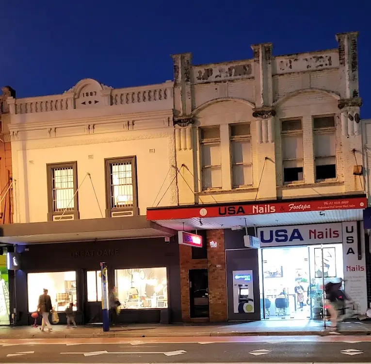 USA Nails shopfront lit up at dusk on Oxford Street, Paddington